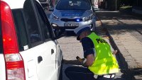 Policjant sprawdzający opony w kontroli auta