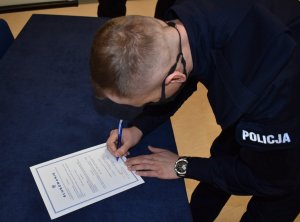 policjant podpisujący akt ślubowania